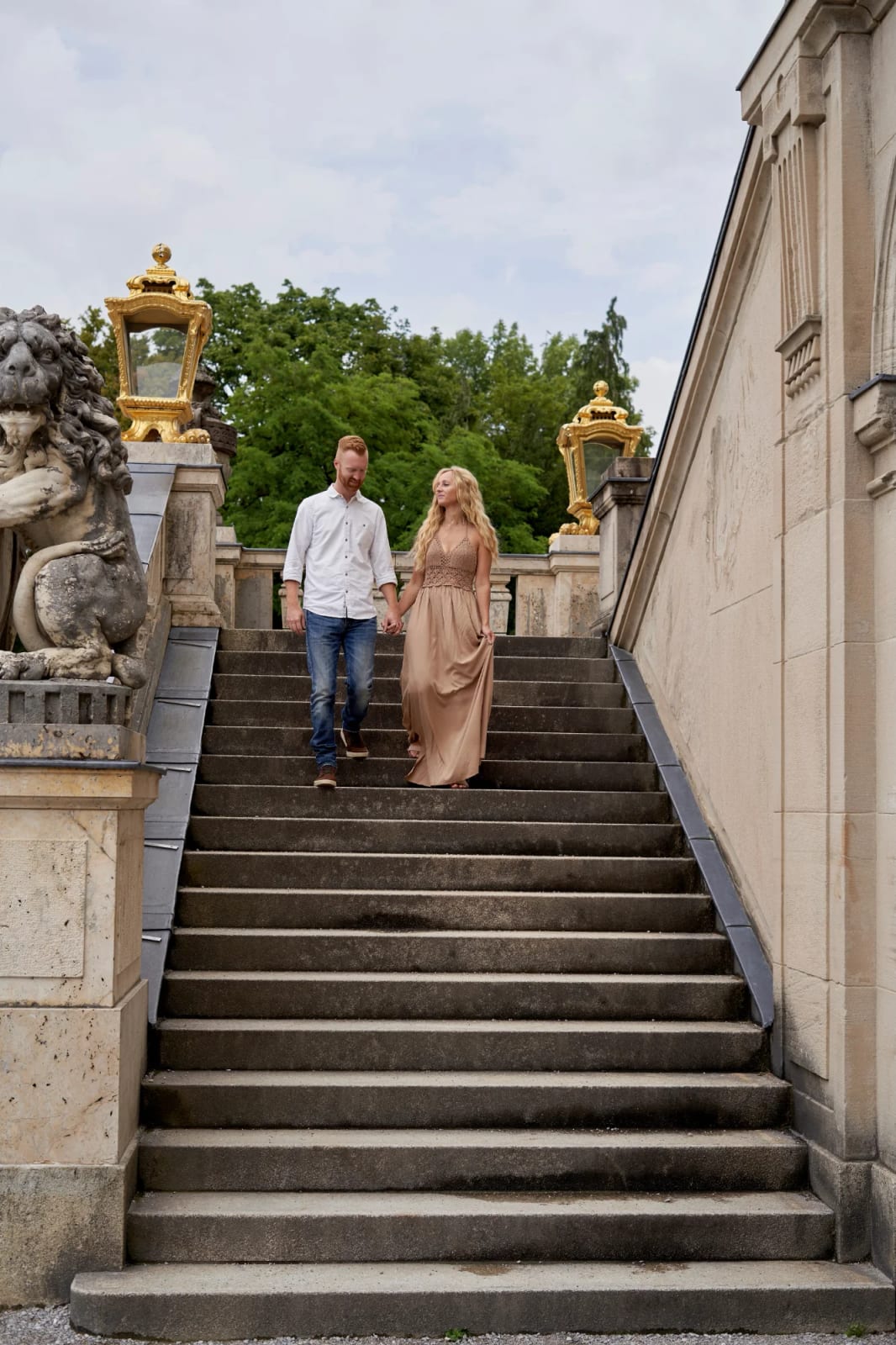 Couple holding hands in front of the baroque façade during a couple photoshoot at Nymphenburg Palace