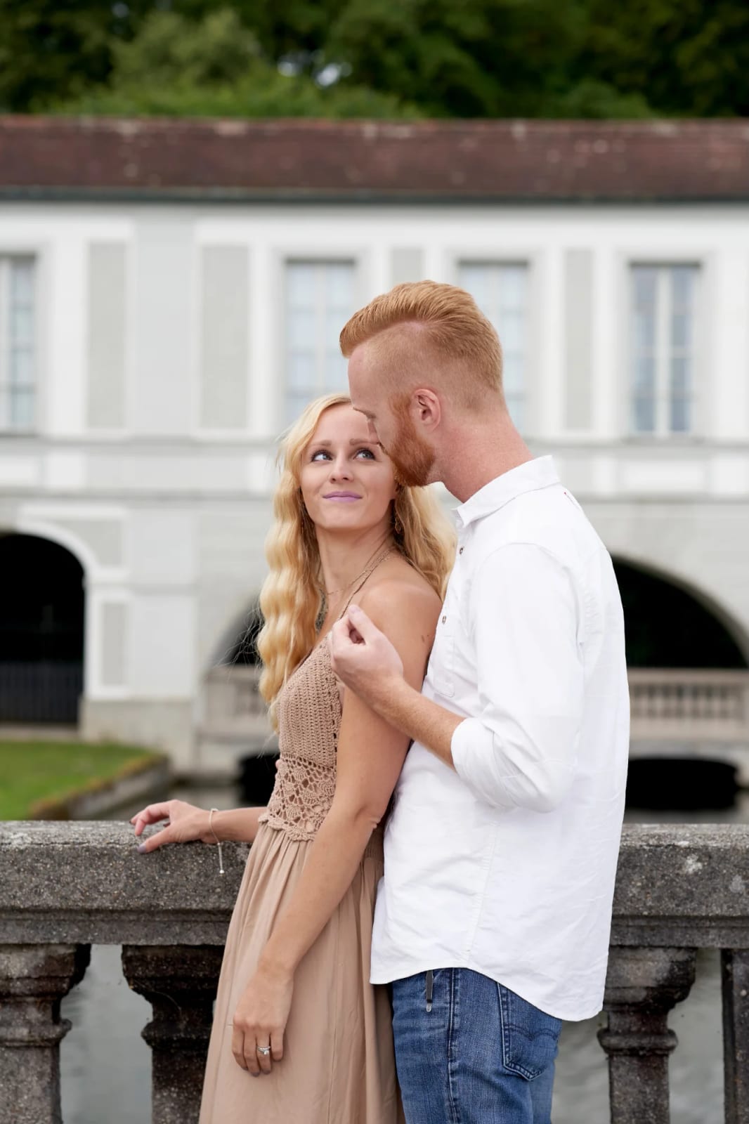 Couple in coordinated outfits in front of the baroque Nymphenburg palace setting