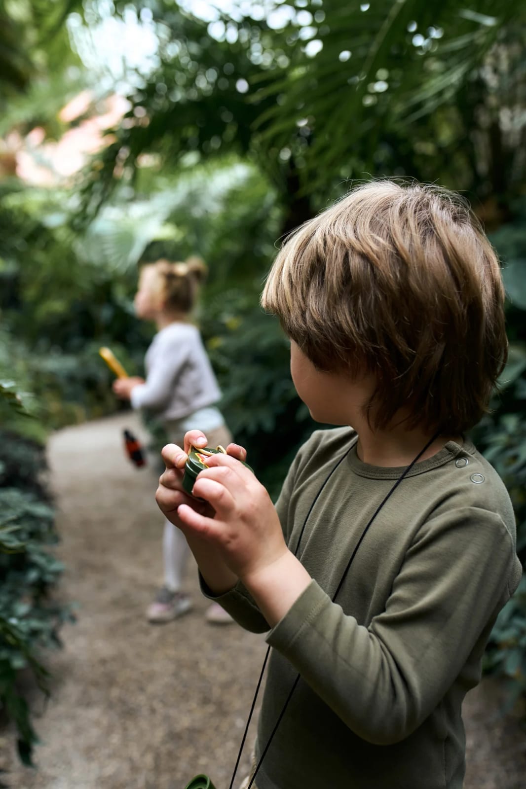 Child with a magnifying glass during a candid themed shoot in the Munich Botanical Garden