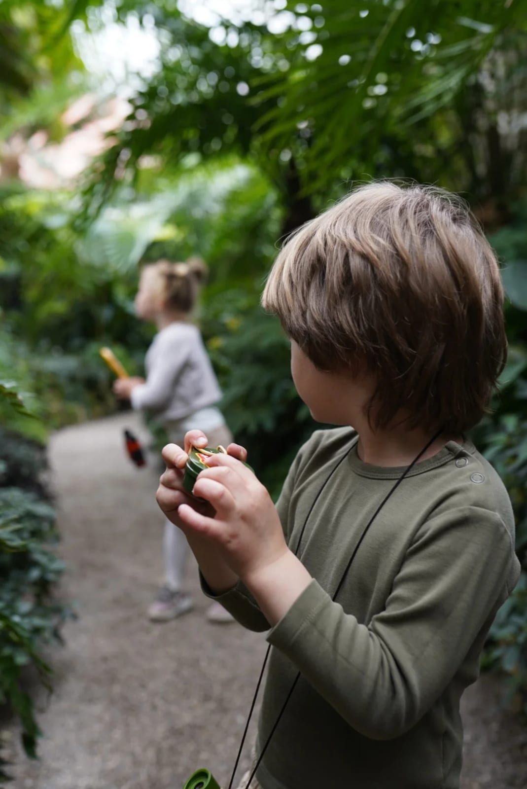 Two siblings discovering something together during a sibling photoshoot in the Munich Botanical Garden